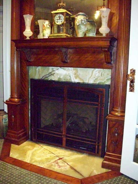 Fireplace surround by Pistritto Marble — green marble surround in a wood-paneled study