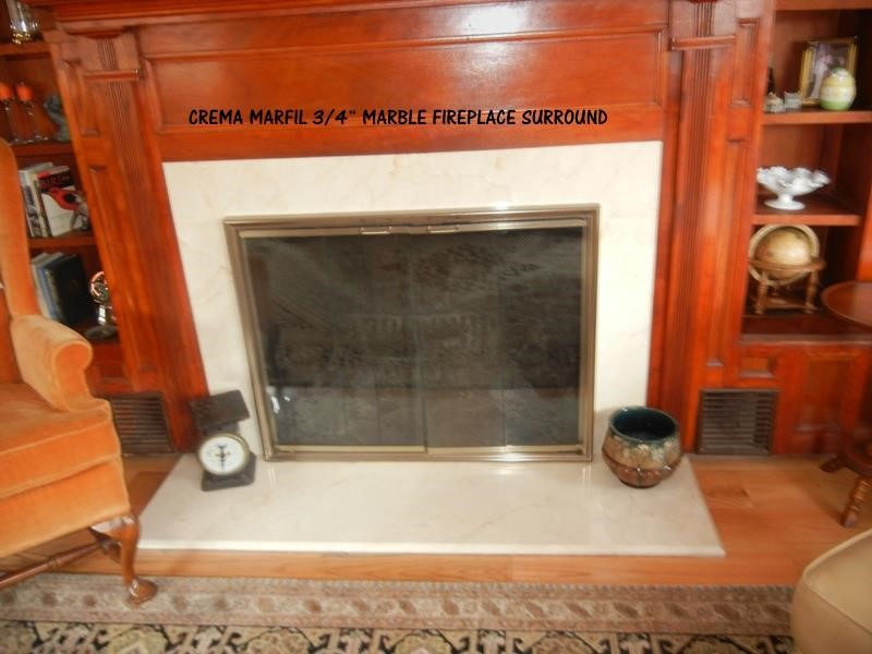 Fireplace surround by Pistritto Marble — crema marble surround with wood mantel