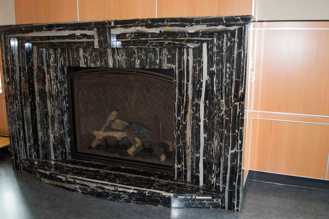 Fireplace surround by Pistritto Marble — dramatic black and gold marble surround