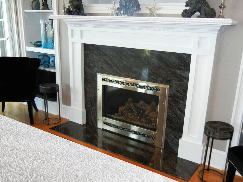 Fireplace surround by Pistritto Marble — dark veined surround with brass screen and white mantel