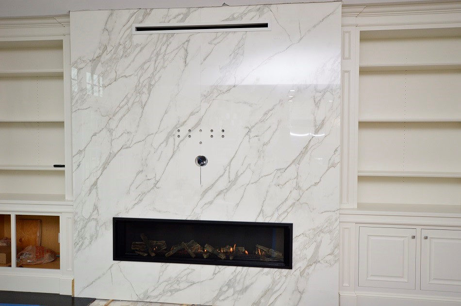 Fireplace surround by Pistritto Marble — floor-to-ceiling veined slab with linear fireplace