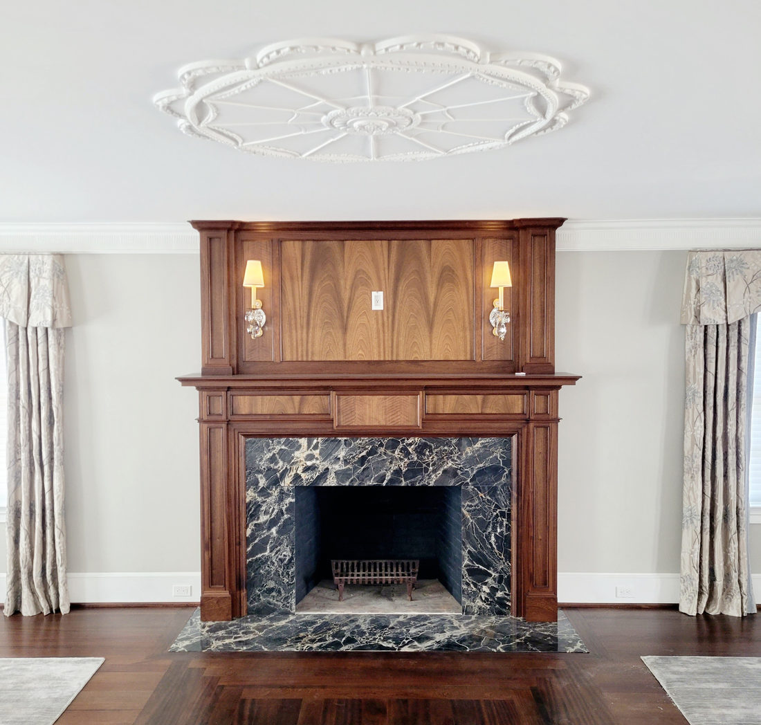 Fireplace surround by Pistritto Marble — black marble surround with wood mantel and columns