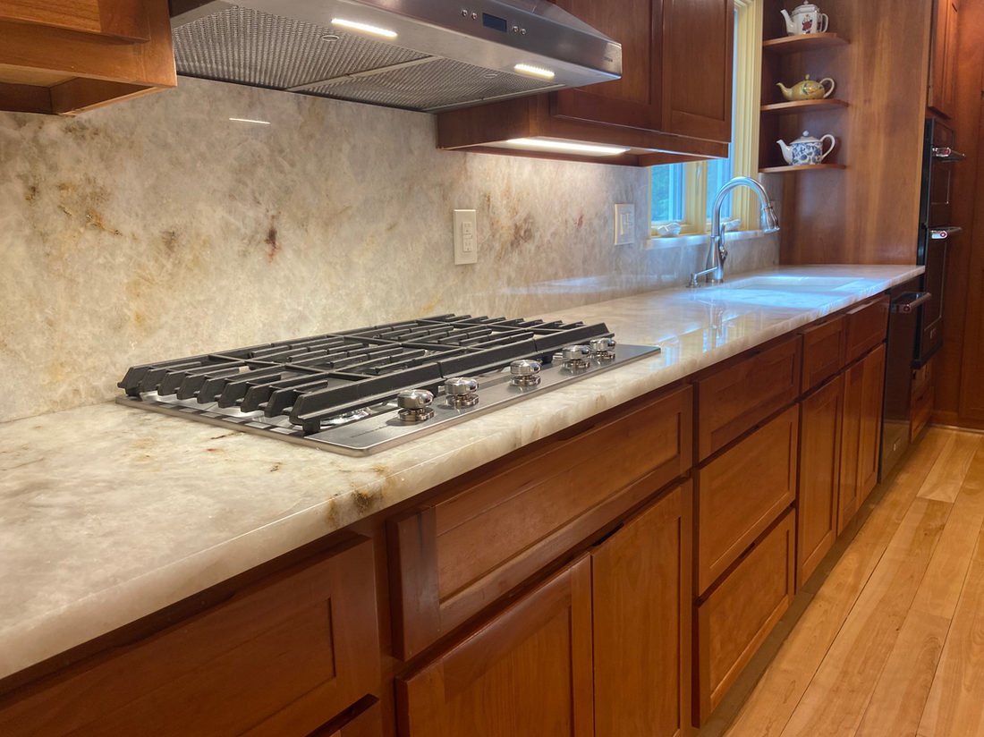 Kitchen countertop project by Pistritto Marble — stone counters and slab backsplash with gas cooktop