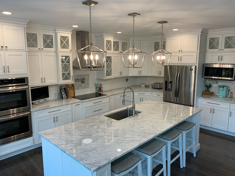Kitchen countertop project by Pistritto Marble — White Carrara marble island with bar seating and lantern pendants
