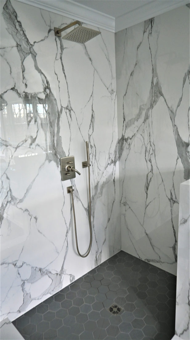 Bath project by Pistritto Marble — full-slab veined shower surround with rain head