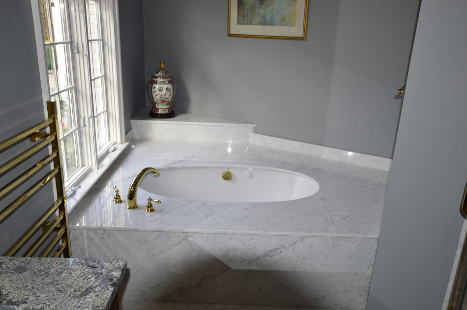 Bath project by Pistritto Marble — stone tub deck with brass fixtures