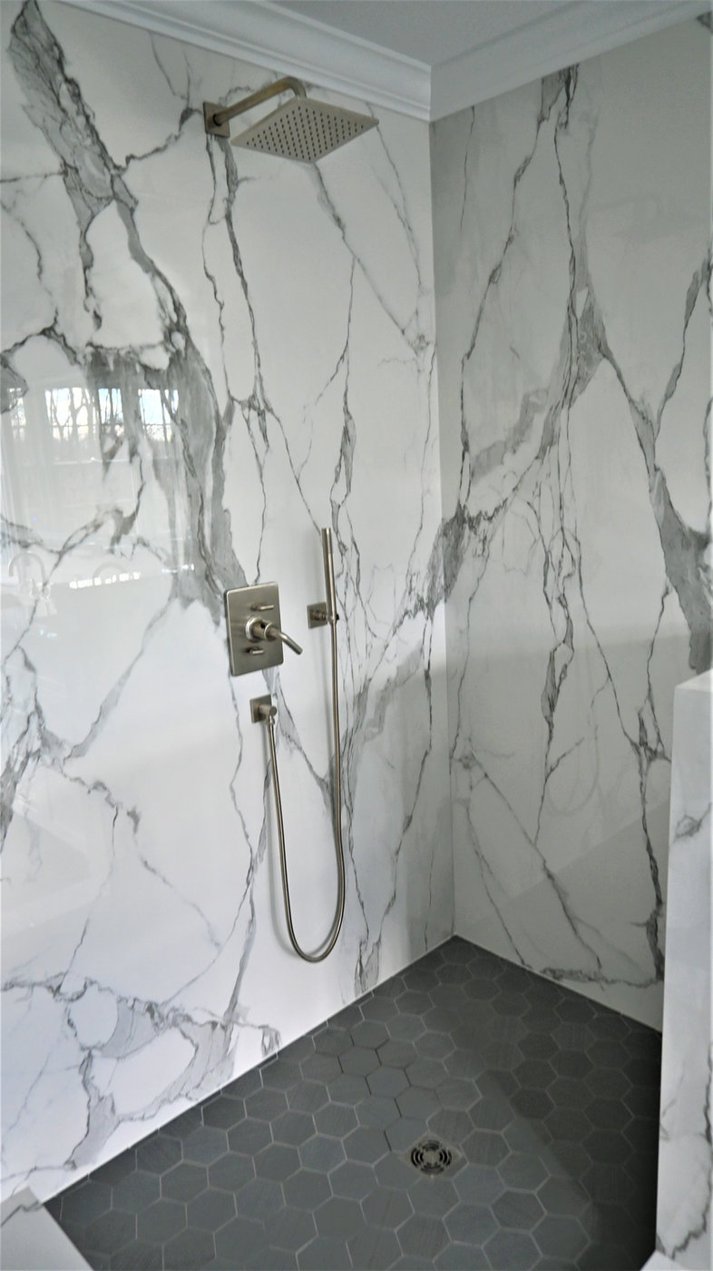 Shower surround built from full-height veined slabs